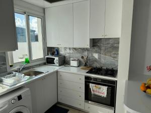 a kitchen with white cabinets and a stove top oven at LATSI BLUE LAGOON 12 in Lachi