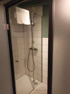 y baño con ducha y puerta de cristal. en So in Sopot Station, en Sopot