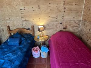 1 dormitorio con 2 camas y mesa con lámpara en Casa D'Pa en San Gerardo de Dota