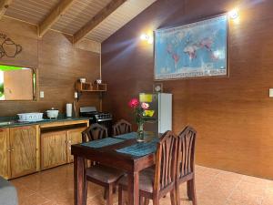a kitchen with a table with chairs and a refrigerator at Casa D'Pa in San Gerardo de Dota