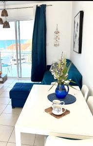 a living room with a white table with a blue vase at LATSI BLUE LAGOON 12 in Lachi