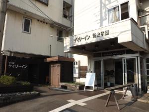 un bâtiment avec un panneau devant lui dans l'établissement Tsukuba Daily Inn, à Tsukuba