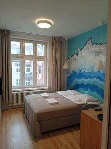 1 dormitorio con 1 cama con una pintura en la pared en So in Sopot Station, en Sopot