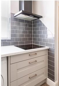 a kitchen with a sink and a stove at Luxury House 4 ensuite bedrooms, free parking ,wifi in Oxford