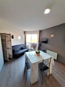 een woonkamer met een tafel en een bank bij studio pour 4 personnes proche du port et des plages in Cap d'Agde