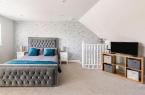 a bedroom with a bed and a flat screen tv at Luxury house with 4 ensuite bedrooms, free parking Wifi in Oxford