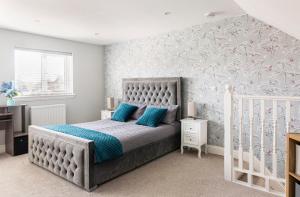 a bedroom with a bed with blue pillows at Luxury house with 4 ensuite bedrooms, free parking Wifi in Oxford