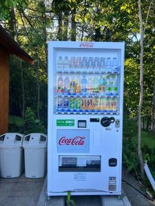 een cocacola koelkast gevuld met flessen frisdrank bij Shirakaba no mori Cottage - Vacation STAY 01176v in Abashiri