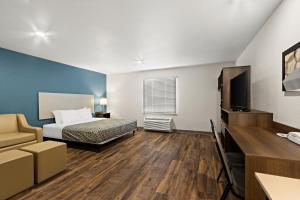 um quarto de hotel com uma cama e uma televisão em WoodSpring Suites Tolleson - Phoenix West em Avondale