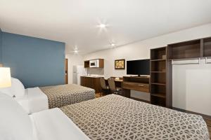 um quarto de hotel com duas camas e uma secretária em WoodSpring Suites Tolleson - Phoenix West em Avondale