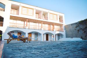 a person sitting on a bench in front of a building at Hotel Sansiraka in Santa Marta