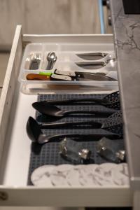 a drawer with knives and utensils in a kitchen at NV HOUSE in Mikrá Mandínia