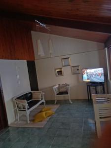ein Wohnzimmer mit einem Sofa und einem TV in der Unterkunft La petite perle in Ducos