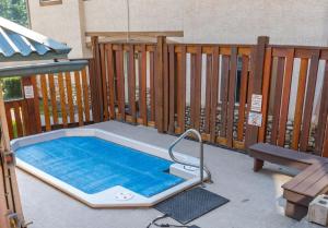 a swimming pool on a patio with a wooden fence at Luxurious Retreat/Hot Tub/Mountain View/4 Beds in Canmore