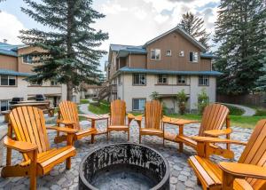 a patio with chairs and a fire pit at Luxurious Retreat/Hot Tub/Mountain View/4 Beds in Canmore