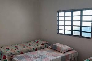 a bedroom with two twin beds and a window at Chácara 15km Tecnoshow Rio Verde in Rio Verde