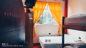 Hostel Flor del Valle في تارابوتو: غرفة نوم بسريرين بطابقين ونافذة