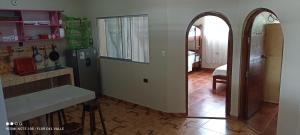 a kitchen with an archway leading to a kitchen with a refrigerator at Hostel Flor del Valle in Tarapoto