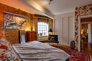 a bedroom with a bed and a brick wall at Luxury Bermondsey Warehouse Loft with Lift in London