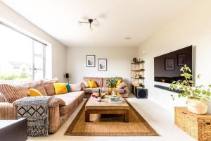 a living room with a couch and a coffee table at Luxury Home with Garden, Gym, Free Parking & Roof Terrace! in Batheaston