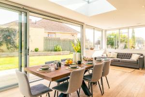 comedor con mesa de madera y sillas en Luxury Home with Garden, Gym, Free Parking & Roof Terrace! en Batheaston