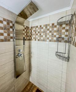 La salle de bains est pourvue d'une douche et de carrelage sur le mur. dans l'établissement Alyki Salamina House, à Salamine
