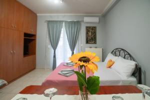 a bedroom with a bed and a vase with a flower on a table at RIRIKA APARTMENT in Igoumenitsa