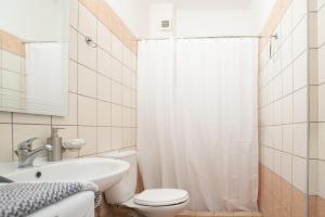 a bathroom with a toilet and a sink and a shower at RIRIKA APARTMENT in Igoumenitsa
