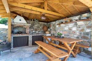 a patio with a wooden table and a fireplace at Rizes House II in Agios Nikolaos
