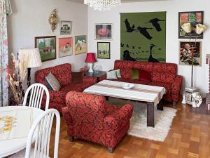 sala de estar con sofá rojo, mesa y sillas en Holiday home Vrigstad en Vrigstad