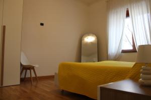 una camera con letto giallo e finestra di Atlantide holiday apartments a Castellammare di Stabia