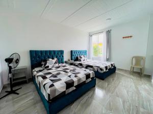 a bedroom with two beds and a window at Hotel Campestre Morichal in Tauramena
