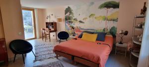 a bedroom with a bed with a painting on the wall at La Sorellerie in Saint-Avertin