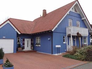 niebieski dom z czerwonym dachem w obiekcie Holiday apartment Alleblas w mieście Geldern
