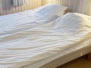 HåcksvikにあるHoliday Home Påarpsの白いシーツが敷かれたベッド