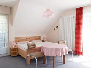 een slaapkamer met een bed en een tafel en stoelen bij Holiday house by the lake in Sankt Peter