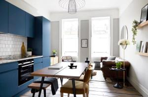 a kitchen with blue cabinets and a table and chairs at Stunning 1 Bedroom Apartment minutes from Angel Tube in London