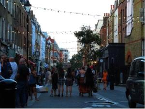 a crowd of people walking down a busy city street at Stunning 1 Bedroom Apartment minutes from Angel Tube in London