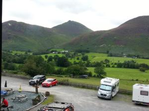 a group of cars parked in a parking lot with mountains at Swinside Inn in Keswick
