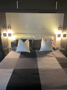 ミラノにあるIsola Apartmentのベッドルーム1室(大型ベッド1台、白い枕2つ付)