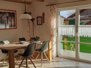 uma sala de jantar com uma mesa e cadeiras e uma janela em Holiday apartment Küber em Altusried