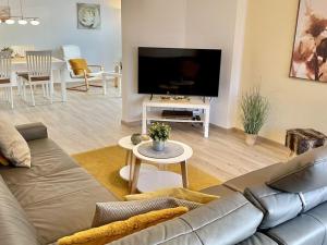Una sala de estar con un sofá y un televisor de pantalla plana. en Holiday apartment SonnenNest, en Braunau