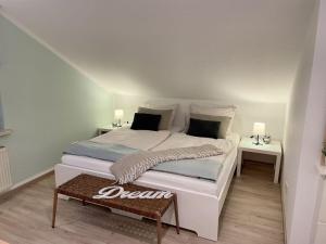 Un dormitorio con una gran cama blanca con dos mesas. en Holiday apartment SonnenNest, en Braunau