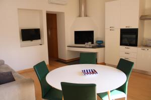un soggiorno con tavolo bianco e sedie verdi di Atlantide holiday apartments a Castellammare di Stabia