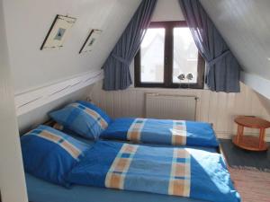 een slaapkamer met 2 bedden en een raam bij in the Achtern Diek holiday park in Burhave