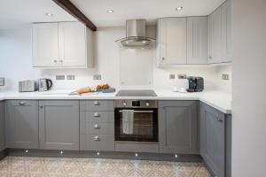 a kitchen with gray and white cabinets and an oven at Castle Retreat - luxury apartment opposite Alnwick Castle in Alnwick +19 photos