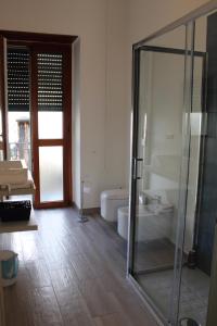 e bagno con vasca e doccia in vetro. di Atlantide holiday apartments a Castellammare di Stabia