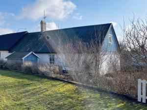 4 person holiday home in TOMELILLA-By Traum في توميليلا: منزل أبيض كبير على سقف أسود