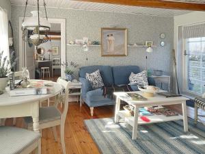 ein Wohnzimmer mit einem blauen Sofa und einem Tisch in der Unterkunft Holiday home TOMELILLA V in Tomelilla
