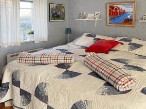 ein Schlafzimmer mit einem Bett mit zwei Kissen darauf in der Unterkunft Holiday home TOMELILLA V in Tomelilla